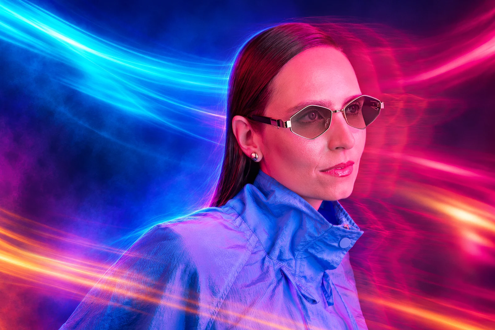 Mulher usando óculos de lentes claras diante de rastros de luz coloridos